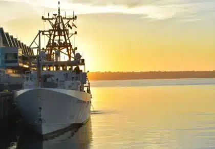 Chantier naval en plein jour avec mains d'ouvriers et plans, bâtiment naval en arrière-plan flou
