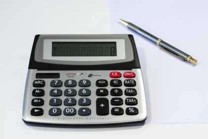 Feuille de paie et calculatrice sur un bureau lumineux près d'une fenêtre